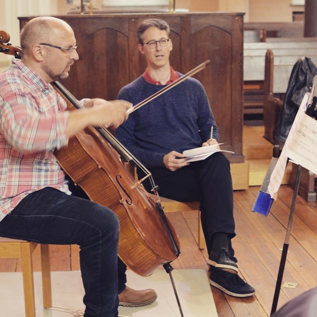 Cellist och medverkande med noter under genrepet